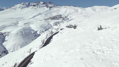 toma de drones de la carretera camino a la exclusiva estación de esquí de la parva llena de nieve en un día soleado en los andes, chile.