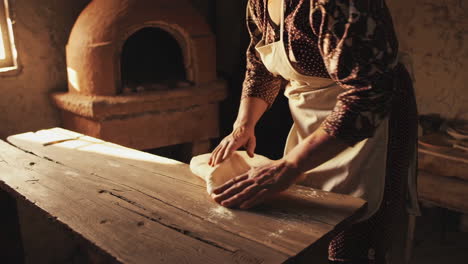 woman kneading dough in a rustic kitchen