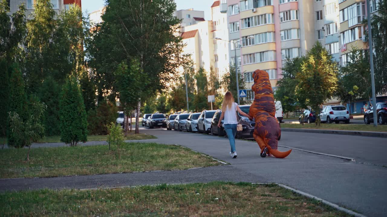 T rex mascot costume on street. Man in T rex cute costume outdoor in modern city