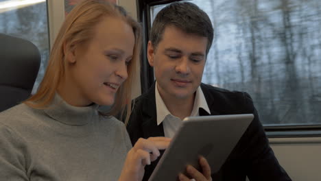 Jóvenes-Trabajando-Con-Pad-Y-Hablando-En-El-Tren.