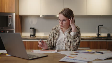 thoughtful woman with glasses working on financial documents concept of the student learning process concept of creative remote work