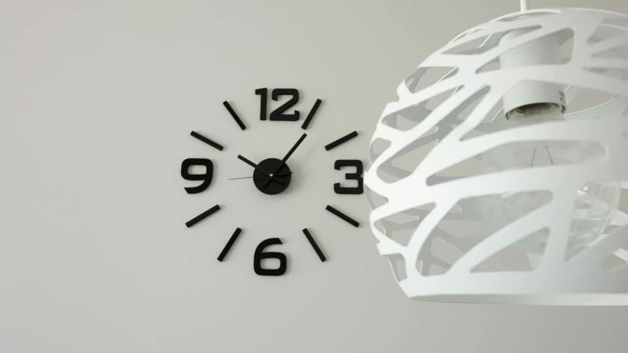 The white hanging lamp on the ceiling and the wall clock in Estonia