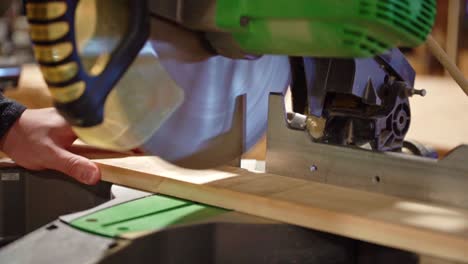cámara lenta de una sierra de inglete cortando placa de aluminio en un taller industrial