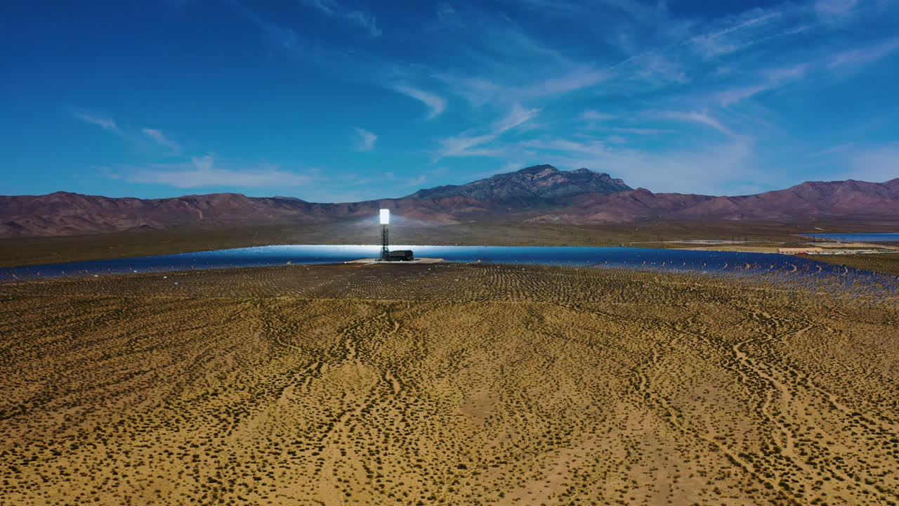vista aérea que se eleva hacia una torre solar térmica en una planta de energía heliostática, en el soleado suroeste de los estados unidos
