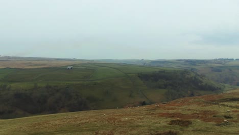 Drone-view-of-large-valley-in-yorkshire-England-on-cloudy-day-covered-in-grass,-sheep-and-very-rural-and-secluded