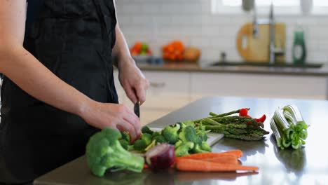 mujer cortando verduras en la cocina en casa 4k