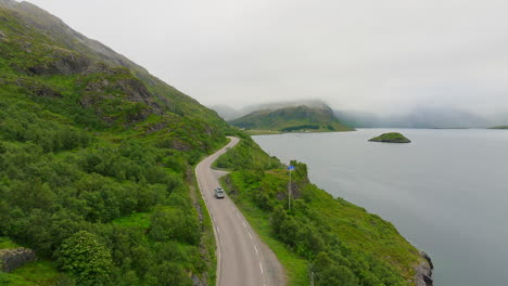 Vehicle-driving-on-Lofoten-island-past-the-water-of-Selfjorden