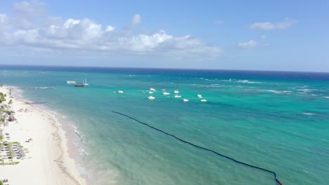 Vista-Aérea-De-La-Playa-De-Arena-Con-Agua-Turquesa-En-El-Paraíso---Hermoso-Día-Soleado-En-La-Costa-Del-Lujoso-Paradisus-Palma-Real-Golf-And-Spa-Resort,-República-Dominicana