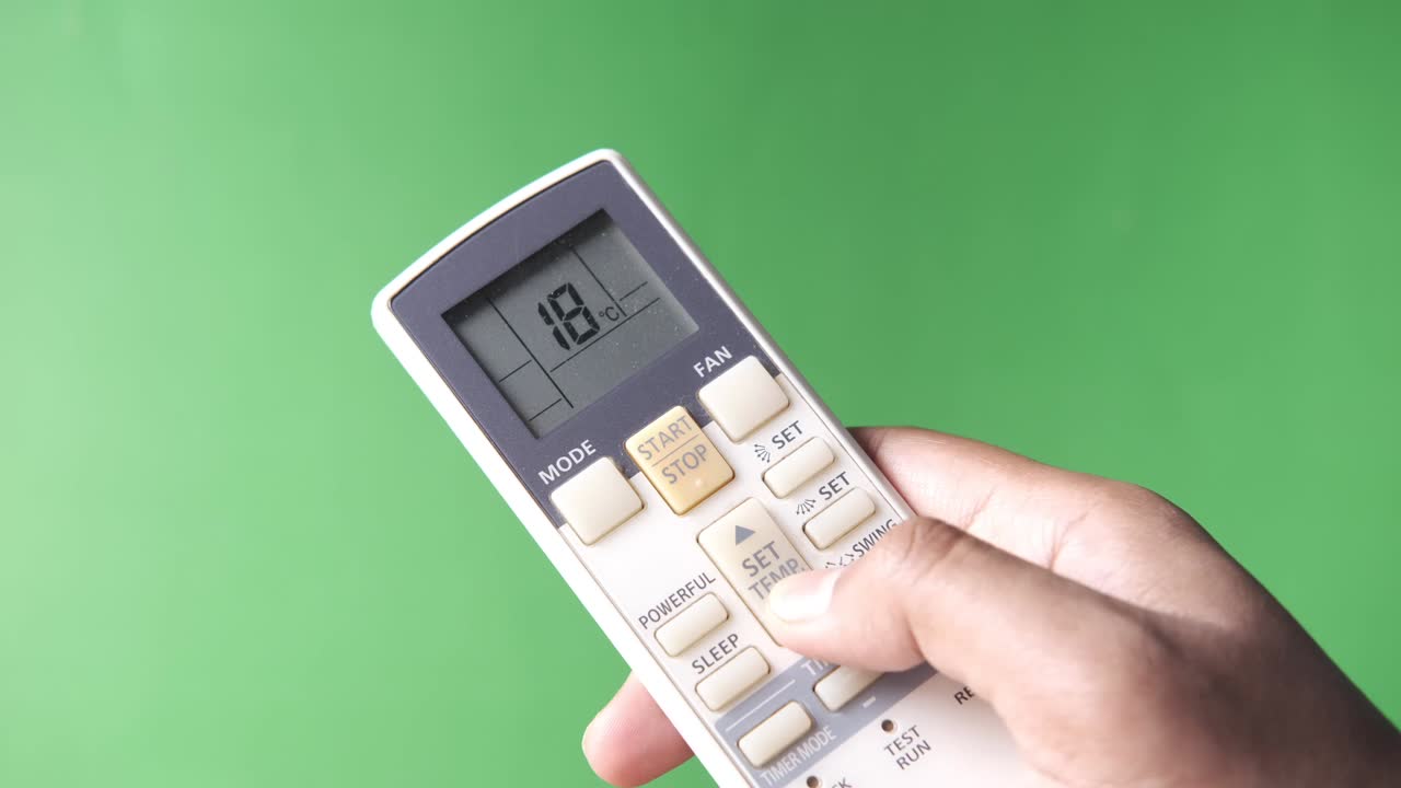 에어컨 리모컨을 들고 있는 손