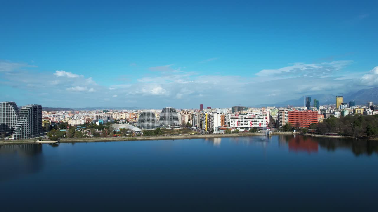el sereno lago de tirana: reflejando cielos azules y edificios arquitectónicos, creando un oasis de tranquilidad en el corazón de la ciudad