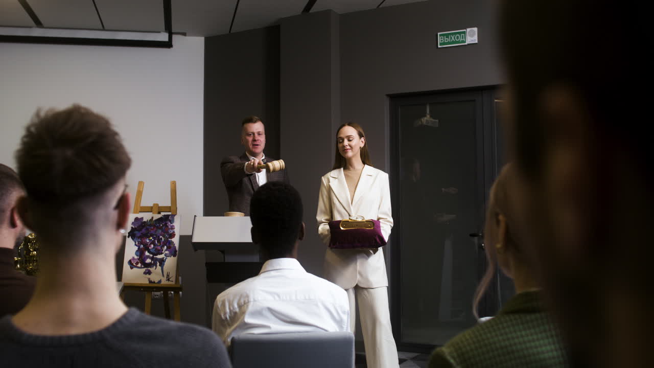 personas en una sesión de subasta de arte