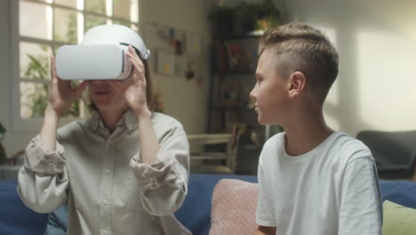 woman and boy interacting with a virtual reality headset at home