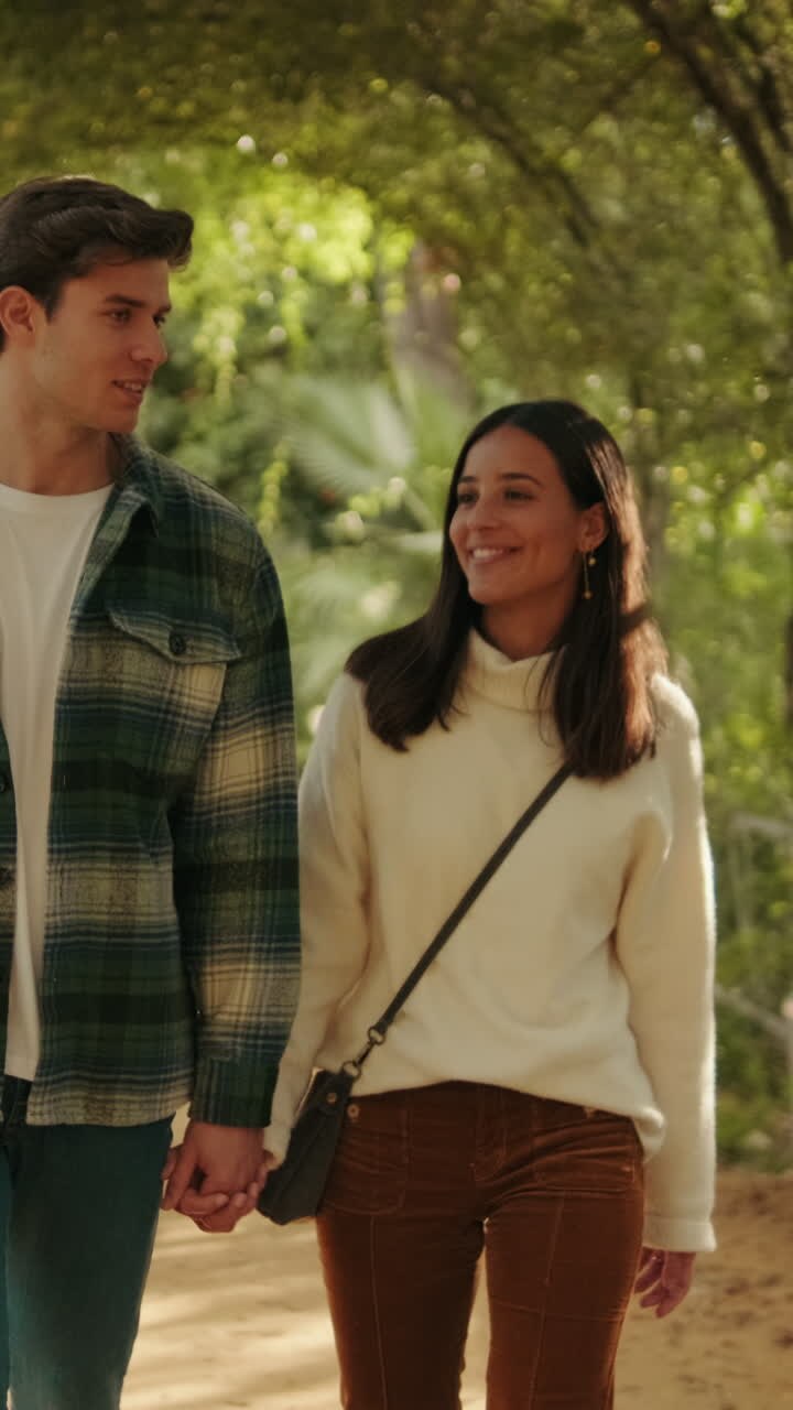 Happy young couple man and woman walking inside green arch