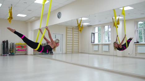 el concepto de deportes para un estilo de vida saludable. la chica ha sido aerología de antigravedad se relaja y se balancea en el lienzo en una habitación blanca