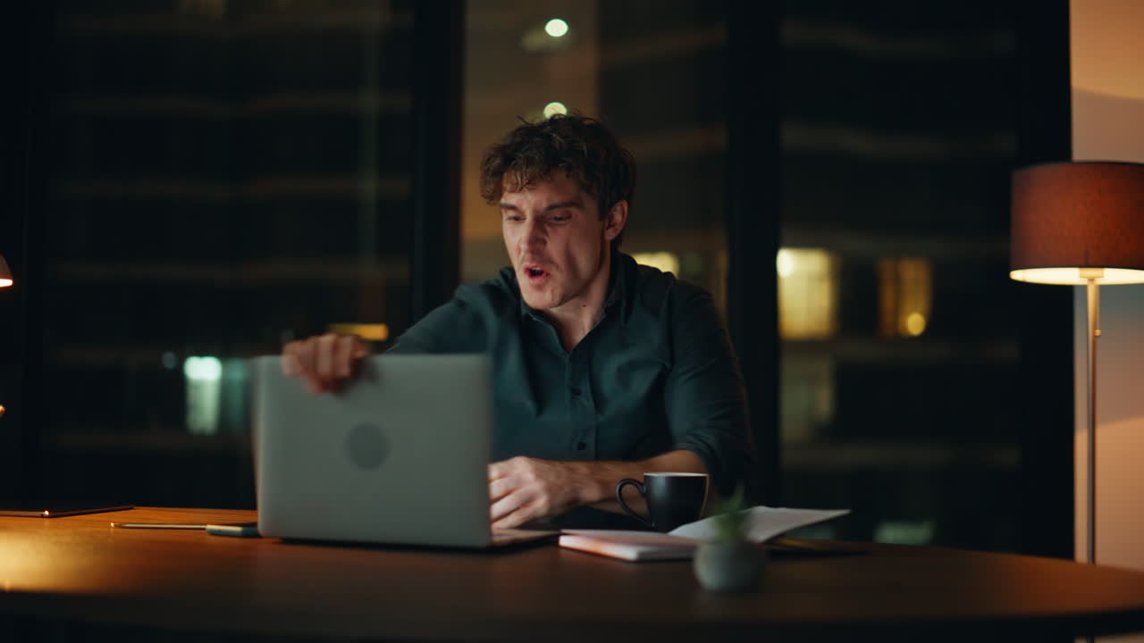 Angry ceo quarrelling virtual conference at night office. Nervous businessman