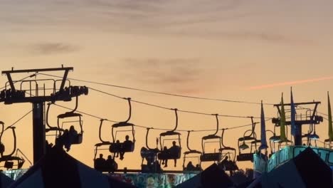 Setting-sun-silhouettes-the-sky-tram-ride-at-the-North-Carolina-State-Fair-in-Raleigh,-NC,-2019