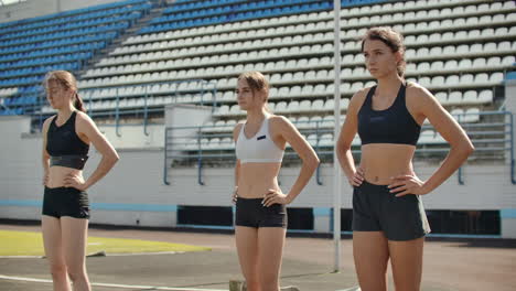 Vista-Lateral-De-Un-Grupo-De-Atletas-Femeninas-Comenzando-Su-Sprint-En-Una-Pista-De-Atletismo.-Corredor-Despegando-Desde-La-Parrilla-De-Salida-En-La-Pista-De-Atletismo.