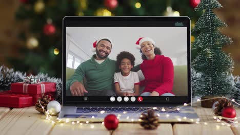 Familia-Feliz-Con-Gorros-De-Papá-Noel-En-Videollamada-Portátil,-Con-Adornos-Navideños-Y-árbol