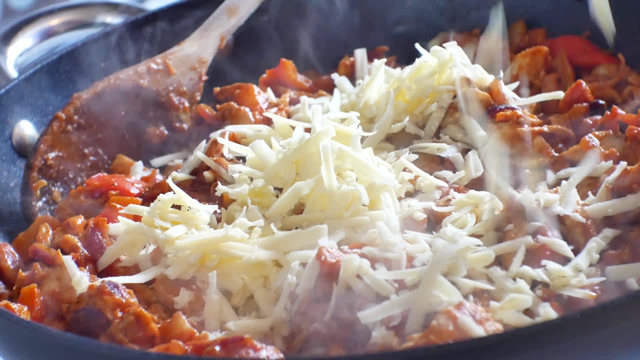 cierre en una sartén humeante caliente llena de deliciosas verduras cubiertas con salsa roja