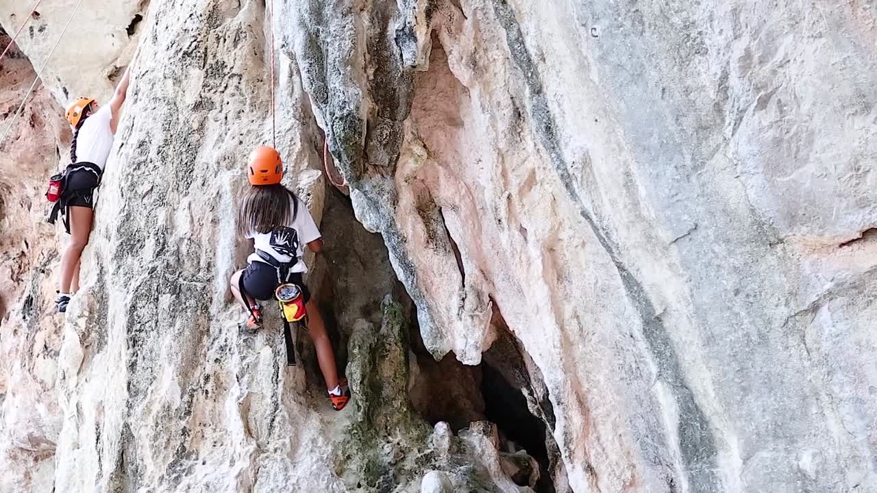 Climber ascends limestone cliff in Krabi, Thailand