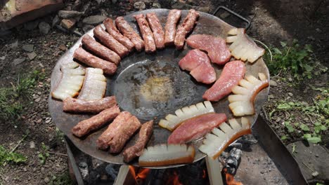 traditional romanian foods mititei, slanina and pork meat cooking over wood fire