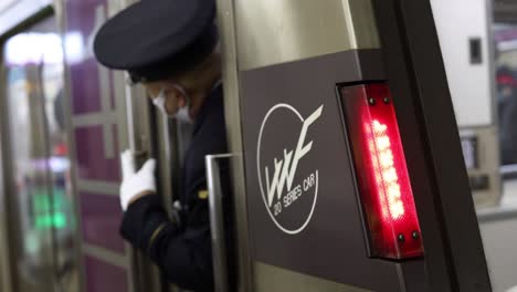 uniformed conductor interacting with station turnstile