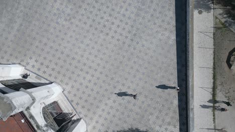 desde arriba, las aceras de lisboa bullen de gente deslizándose juguetonamente