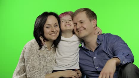 familia feliz de tres padre, madre e hija. abrazar, jugar, reír, sonreír