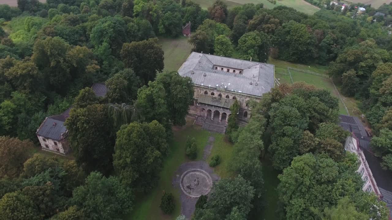 중부 유럽에 있는 버려진 궁전, 초록색 나무가 있는 공원, 건조한 분수, 외 건물로 둘러싸인 4k 드론 촬영
