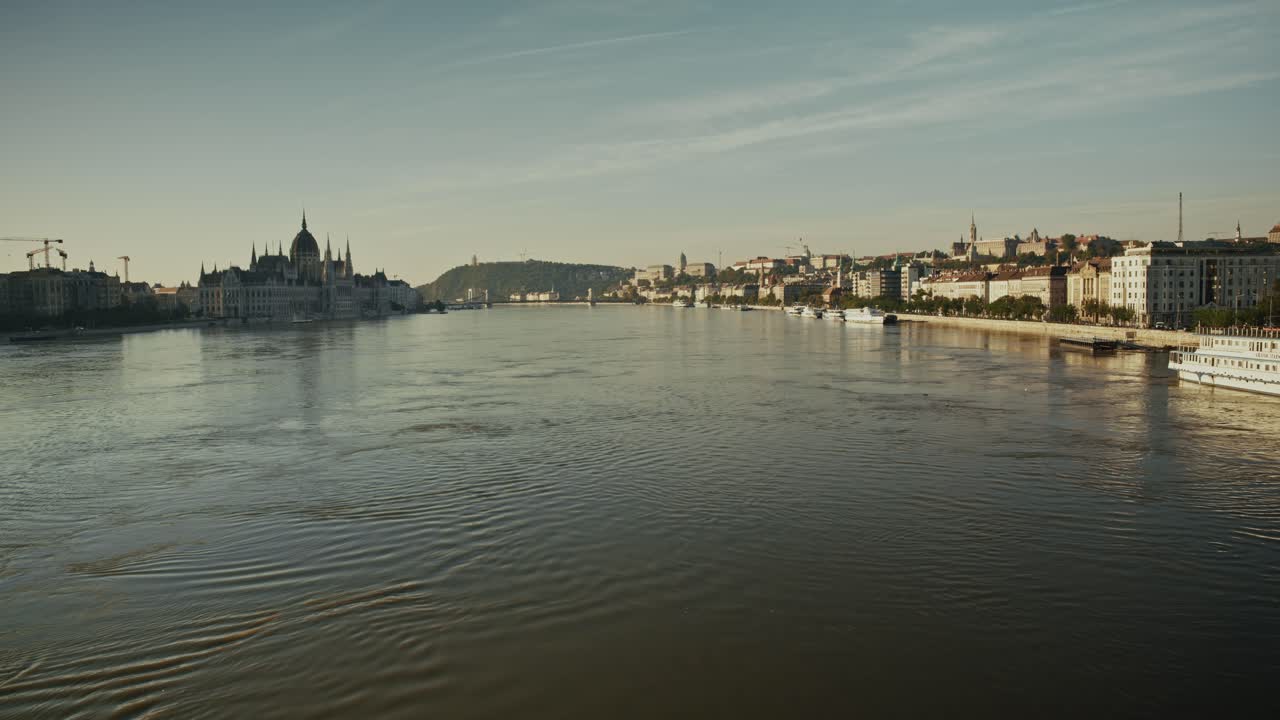 Fiume che inonda le rive di Budapest, mostrando il Parlamento distante e gli edifici lungo il fiume sotto un cielo calmo e coperto