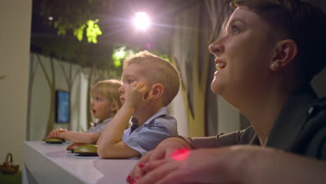 dos niños pequeños disfrutando con su madre durante una visita al museo, de cerca