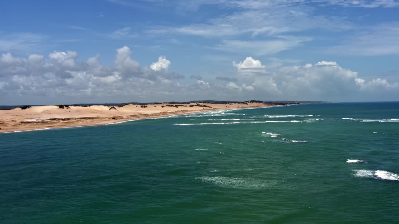 Left trucking aerial drone shot of the Malemb&aacute; crossing where the atlantic ocean joins with the Guara&iacute;ras lagoon with large sand dunes in Tibau do Sul near Pipa, Brazil in Rio Grande do Norte