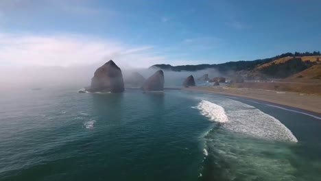 AERIAL:-Drone-shot-flying-towards-large-rock-formations-within-Oregon's-Pacific-ocean