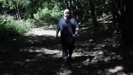 a man walking through forest trees