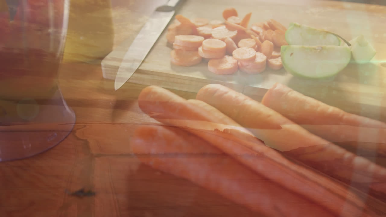 부에서 잘라진 당근, 칼 및 기 보드 위에 반이는 빛의 반점의 애니메이션