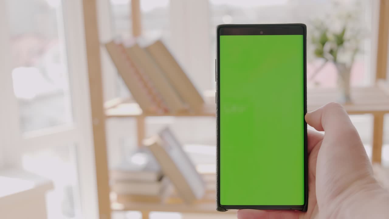 pov vista de un hombre en casa usando un teléfono inteligente con pantalla de maquillaje verde, versión 1