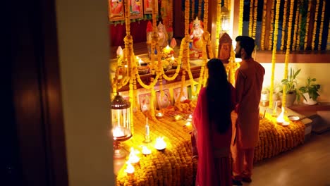 pareja orando en el santuario de la casa durante diwali