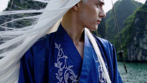 man in traditional blue kimono with white hair, profile view