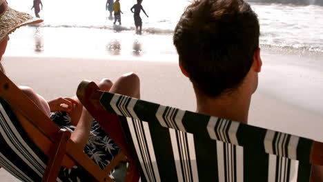 Couple-sitting-on-sunchair-while-sunbathing