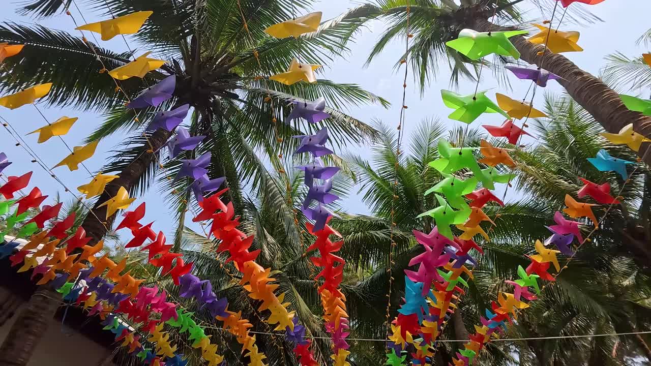 Colorful Decorations Hanging from Palm Trees
