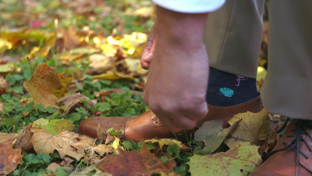 Man tying shoelaces on dress shoes, getting ready for a wedding