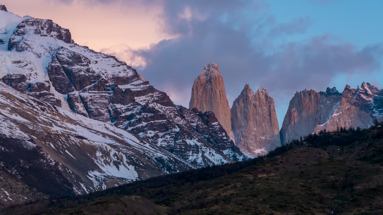 Luce del tramonto che cambia con nuvole che si addensano sul paesaggio montano di Torres del Paine