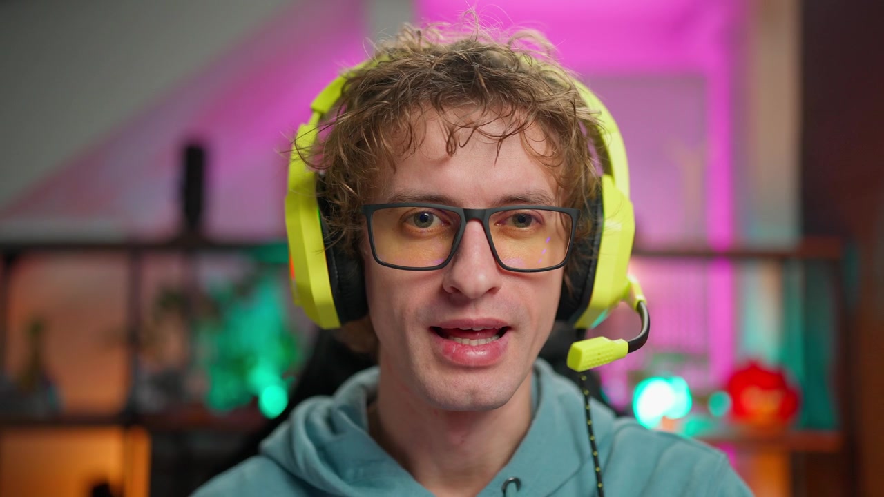 Giovane uomo con cuffie da gaming che parla alla telecamera