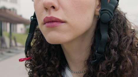 close up of a young woman wearing a bicycle helmet outdoors