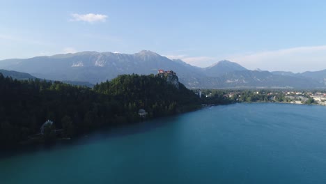 Luftdrohnen-Fliegen-über-Dem-Touristenziel-Bleder-See-In-Den-Slowenischen-Alpen,-Natürliche-Grüne-Und-Blaue,-Unverschmutzte-Atmosphäre,-Ruhiges-Wasser-Im-Sommer