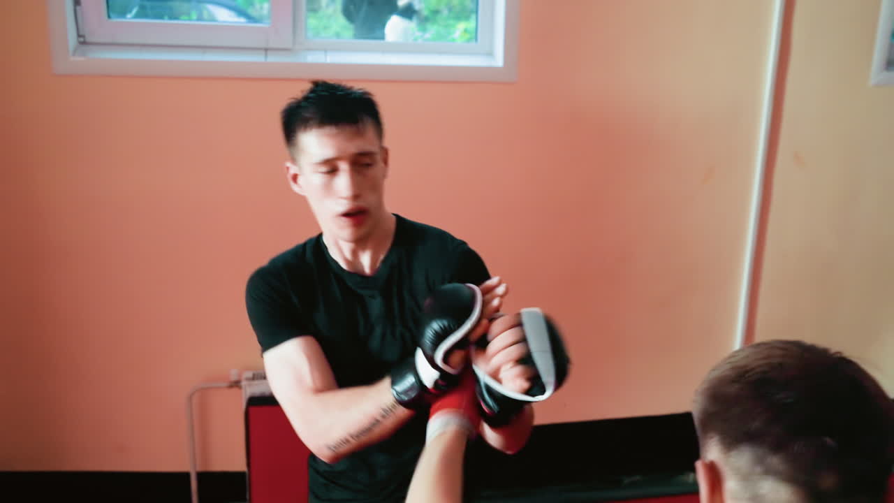 Karate practitioners fighting stance with gloves inside dojo, showing discipline, strength, focus, and determination during martial arts training session with controlled movements