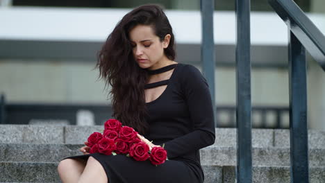 closeup woman sitting in dress at street. woman crying on stairs outdoors