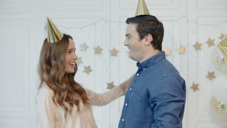 surprised man hugging woman in new year decorated apartment.