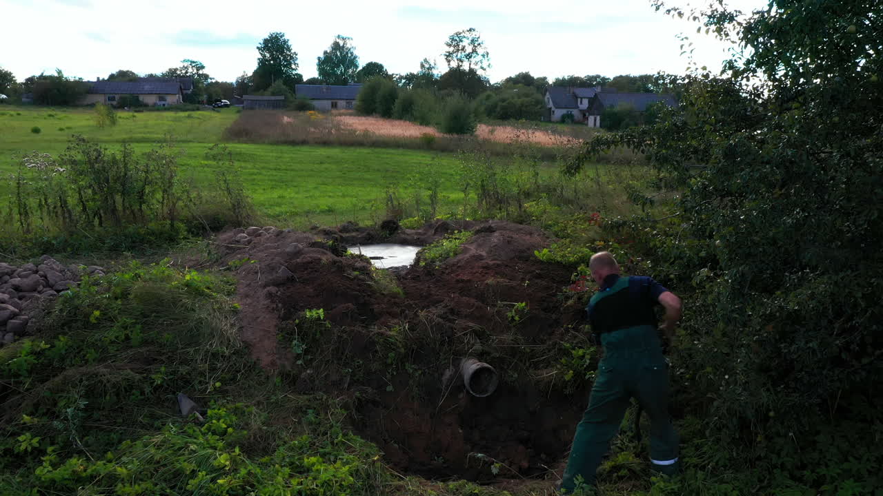 Building smokehouse in backyard - man digging hole for construction