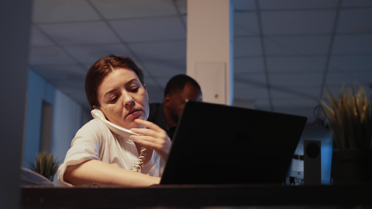Confident successful worker answering landline phone call at office job